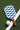 Checkered paddle with brown handle and white ball on green surface